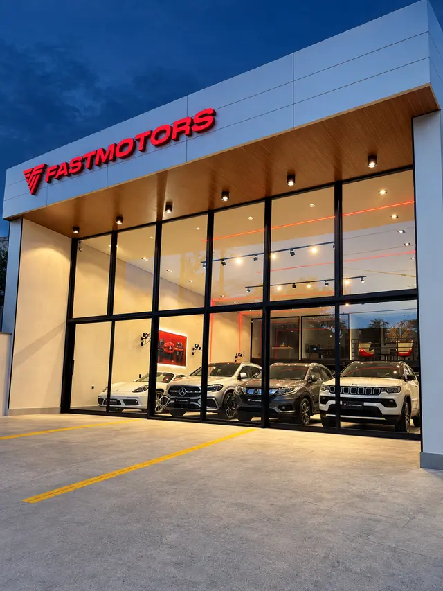 Showroom da FASTMOTORS visto de lado, com carros expostos